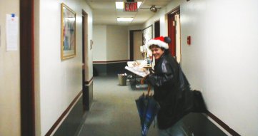 Dr. Jessica Kun in a Santa hat running away from the camera