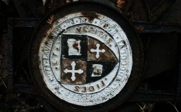 An iron-cast university seal at Sahd's metal salvage and recycling