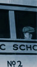 Forlorn boy looking out the window of a schoolbus