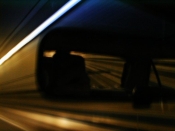 Chesapeake Tunnel at night. Lights painting lines in a rearview mirror.